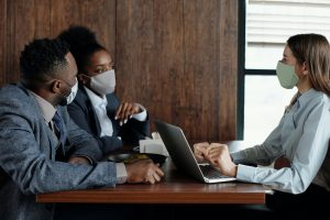 business meeting during covid19 with worker and customer wearing masks